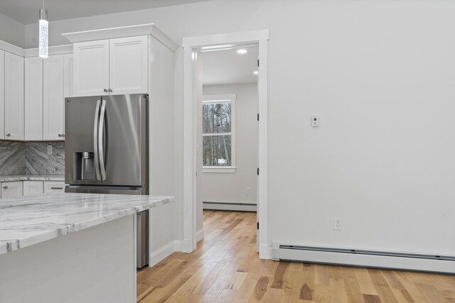 kitchen with baseboard heating, light hardwood / wood-style floors, hanging light fixtures, and white cabinets