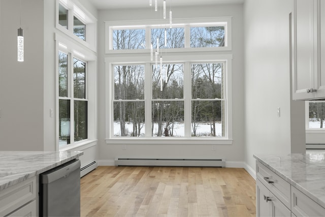 unfurnished dining area featuring a baseboard radiator and plenty of natural light