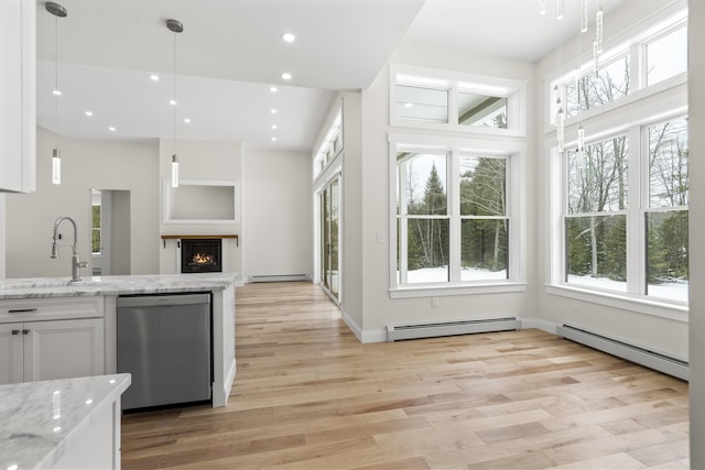 kitchen featuring white cabinetry, stainless steel dishwasher, a baseboard radiator, and sink