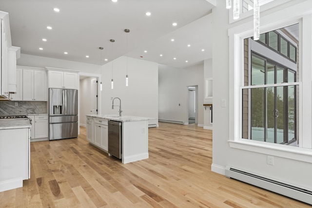 kitchen featuring white cabinetry, a baseboard radiator, appliances with stainless steel finishes, and decorative light fixtures