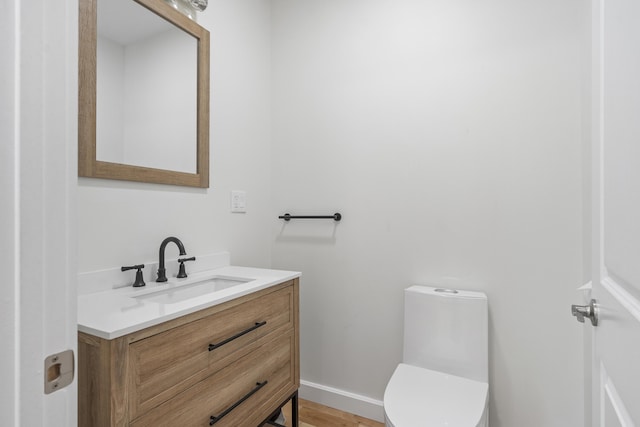 bathroom with vanity, wood-type flooring, and toilet