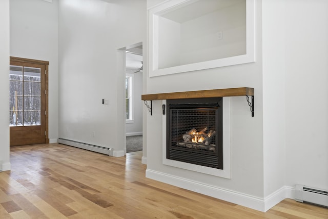 unfurnished living room featuring light hardwood / wood-style floors and baseboard heating