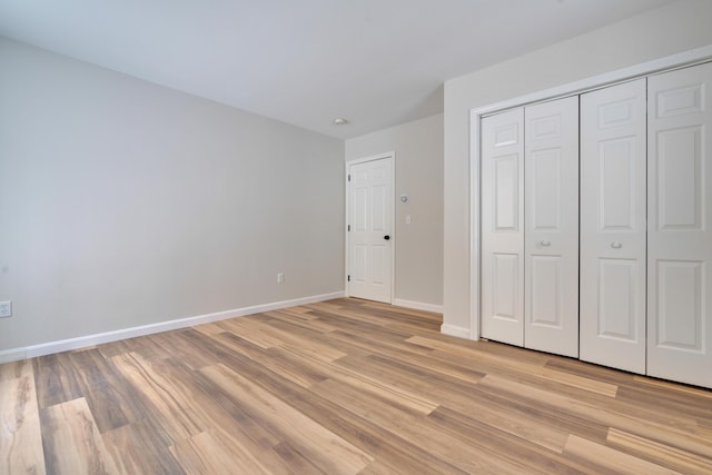 unfurnished bedroom with a closet and light wood-type flooring