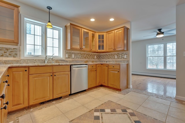 kitchen featuring tasteful backsplash, hanging light fixtures, light tile patterned floors, stainless steel dishwasher, and a baseboard heating unit