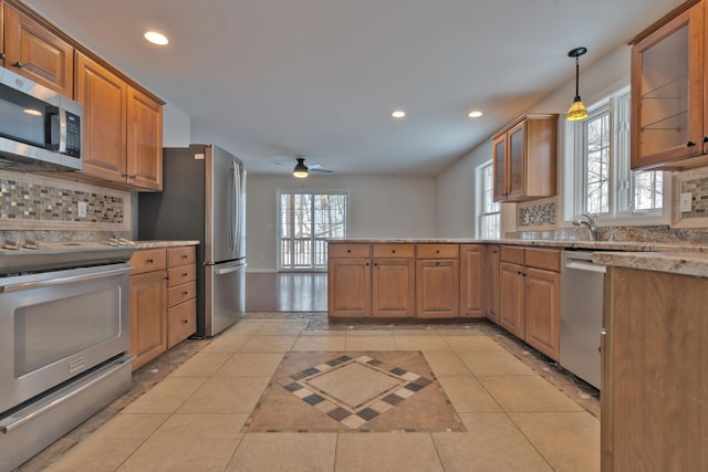 kitchen featuring backsplash, decorative light fixtures, light tile patterned flooring, and appliances with stainless steel finishes