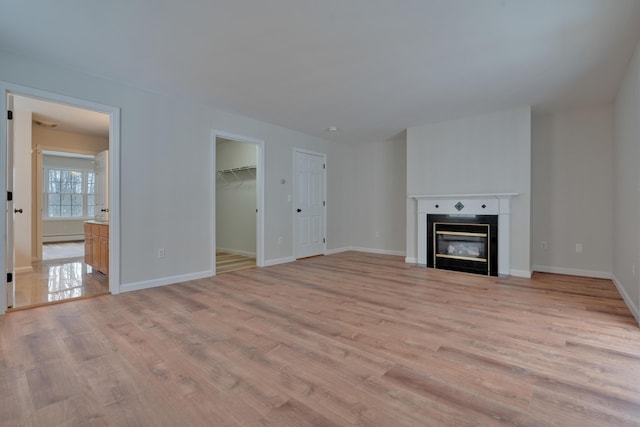 unfurnished living room featuring a baseboard radiator and light hardwood / wood-style flooring