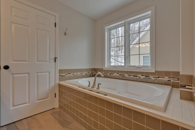 bathroom featuring tiled tub and hardwood / wood-style floors