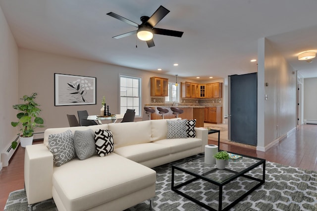 living room with ceiling fan, wood-type flooring, and a baseboard radiator