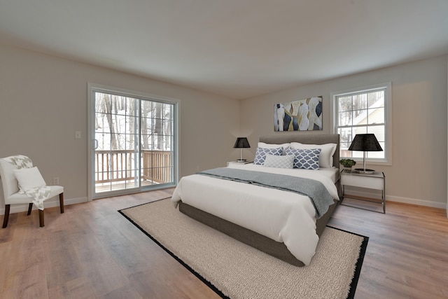 bedroom featuring access to exterior and light hardwood / wood-style flooring