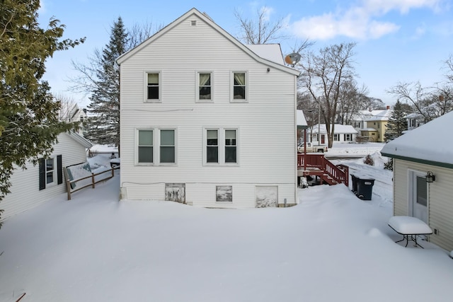 view of snow covered back of property