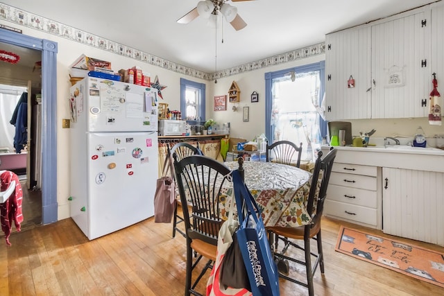 dining area with light wood-style floors and ceiling fan