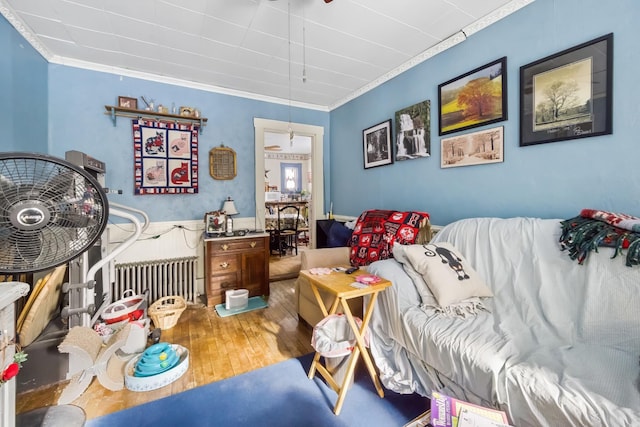 interior space with radiator, crown molding, and wood finished floors