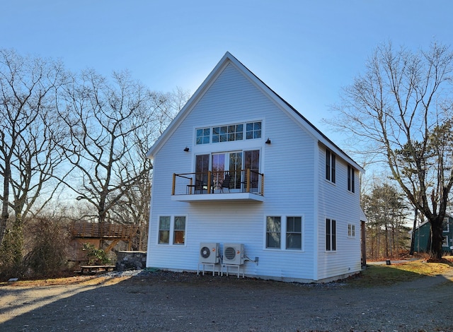 rear view of house featuring ac unit and a balcony