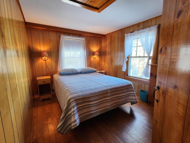 bedroom featuring dark wood-type flooring and wood walls