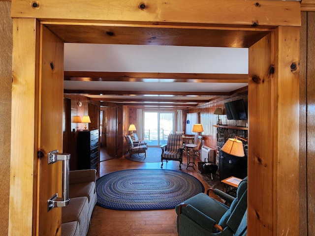 living room featuring beamed ceiling and wood-type flooring