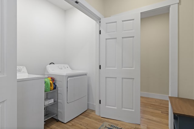 laundry room with washer and clothes dryer and light wood-type flooring