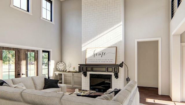 living room featuring hardwood / wood-style flooring, a towering ceiling, and a fireplace