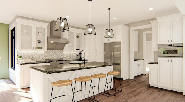 kitchen featuring appliances with stainless steel finishes, sink, a center island with sink, and white cabinets