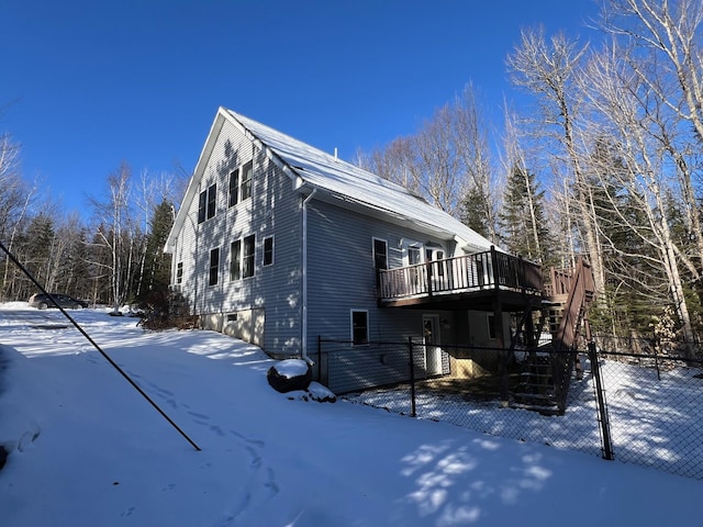 view of snowy exterior featuring a wooden deck and a garage