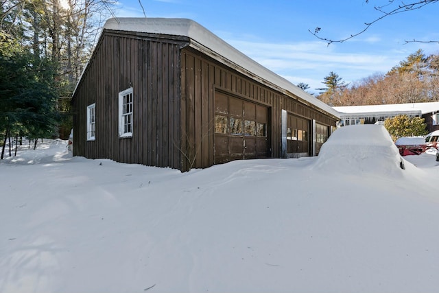 snow covered property featuring a garage