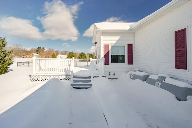 snow covered patio featuring a deck