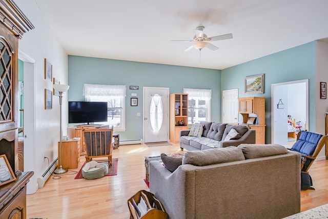 living room featuring baseboard heating, ceiling fan, and light wood-type flooring