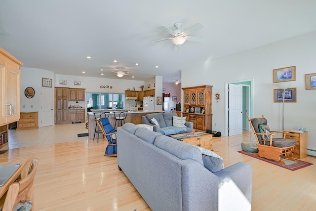 living room featuring light hardwood / wood-style flooring and ceiling fan