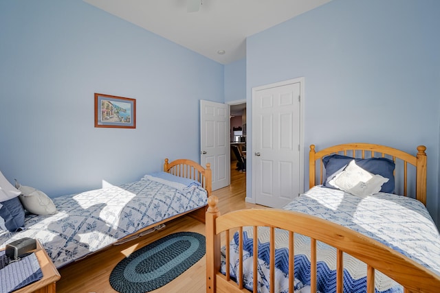 bedroom featuring lofted ceiling, ceiling fan, and light hardwood / wood-style flooring