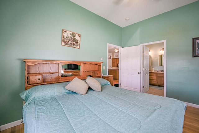 bedroom with ensuite bathroom, ceiling fan, and wood-type flooring