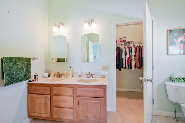 bathroom with toilet, tile patterned flooring, and vanity