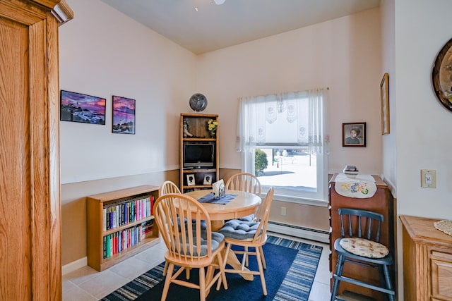 tiled dining area featuring a baseboard heating unit