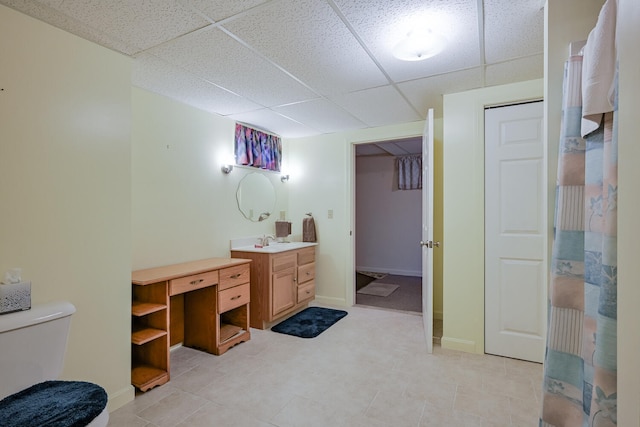 bathroom featuring toilet, a paneled ceiling, and vanity