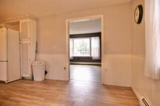 interior space with light hardwood / wood-style floors and a baseboard heating unit