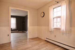 empty room featuring light hardwood / wood-style floors and a baseboard heating unit