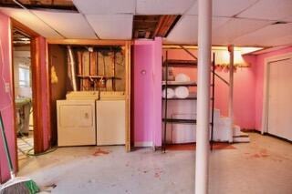 basement featuring separate washer and dryer and a drop ceiling