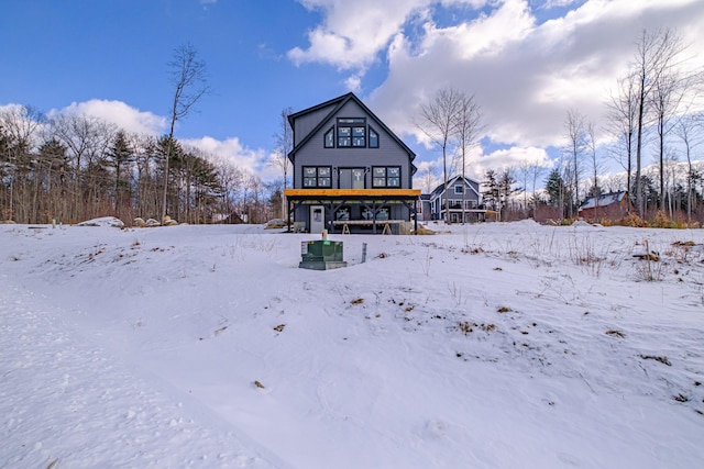 view of snow covered back of property