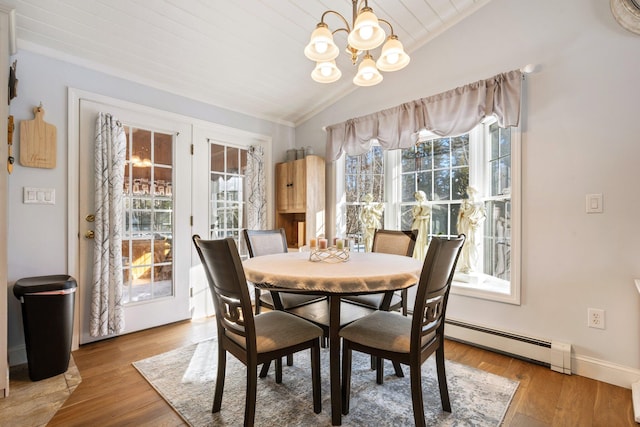 dining space with vaulted ceiling, a baseboard heating unit, hardwood / wood-style floors, and a notable chandelier