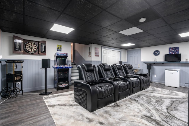 cinema room with hardwood / wood-style floors and a drop ceiling