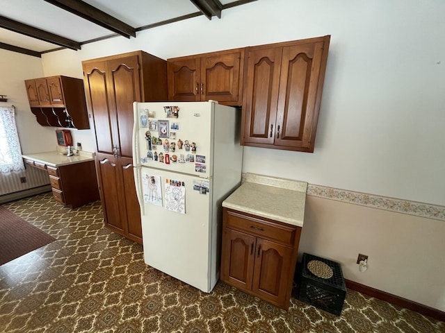 kitchen featuring white fridge and beam ceiling