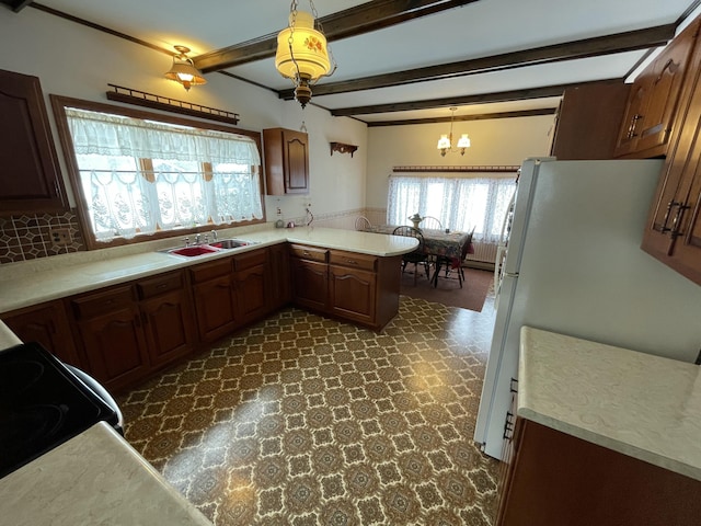 kitchen with sink, hanging light fixtures, white fridge, kitchen peninsula, and beam ceiling