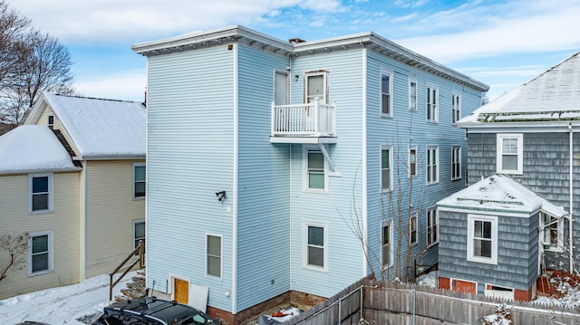 snow covered property with a balcony