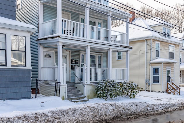 snow covered property entrance featuring covered porch