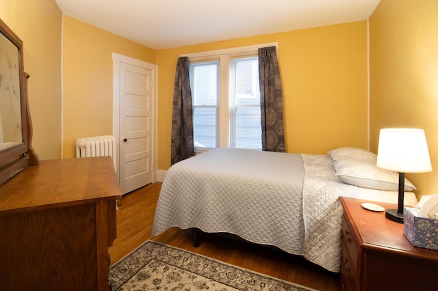 bedroom featuring radiator and hardwood / wood-style floors