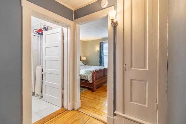 hallway with radiator heating unit and hardwood / wood-style floors