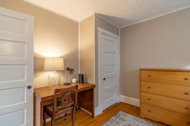 home office with ornamental molding and light wood-type flooring