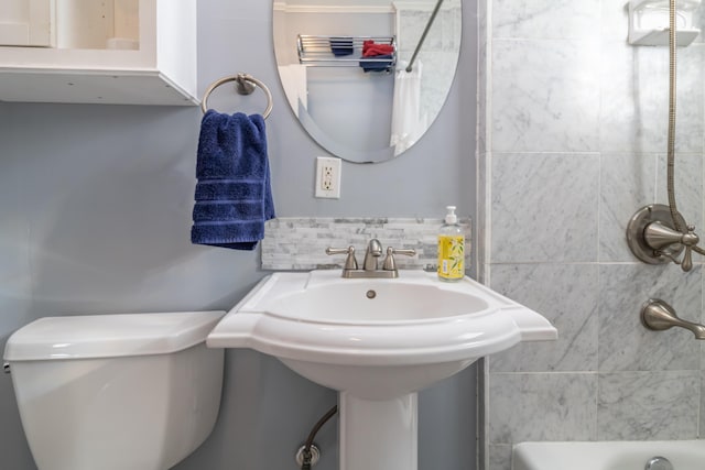 bathroom with toilet and decorative backsplash