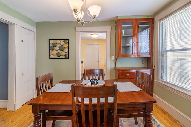 dining space with a notable chandelier and light hardwood / wood-style flooring