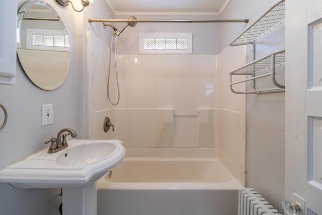 bathroom with bathtub / shower combination, radiator, and sink