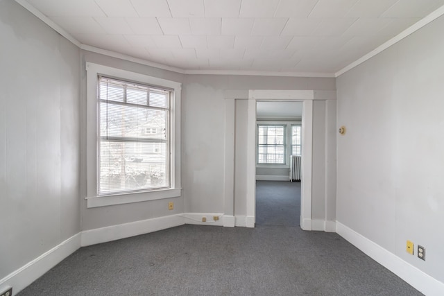 carpeted spare room with radiator and crown molding