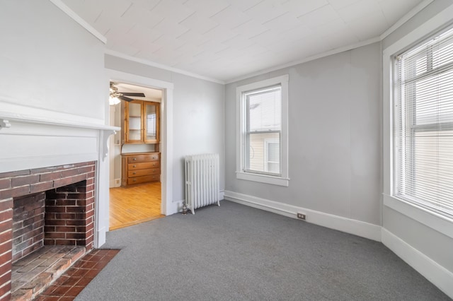 unfurnished living room featuring a fireplace, dark carpet, radiator heating unit, and ornamental molding